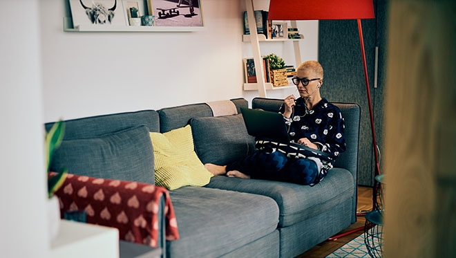 Woman working on a laptop from the sofa