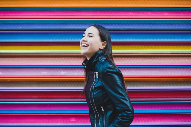 Happy woman in front of colorful wall