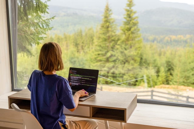 Woman coding in the woods
